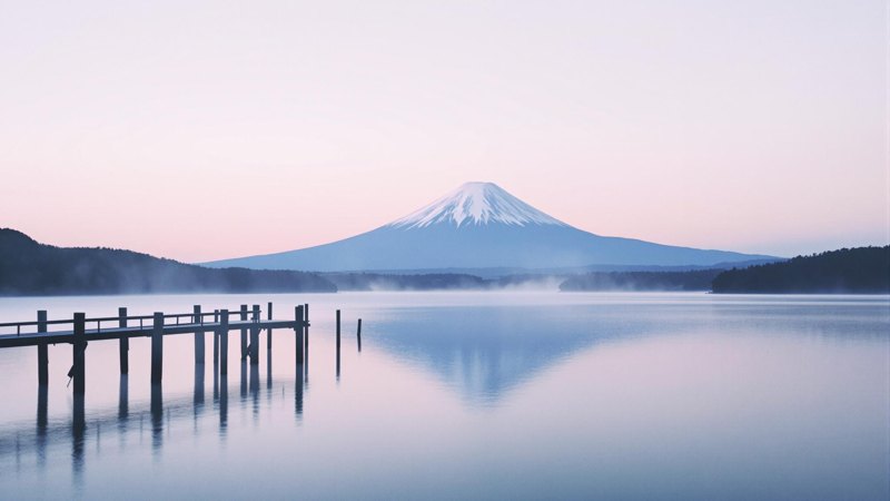 Mount Fuji across a still lake at dawn